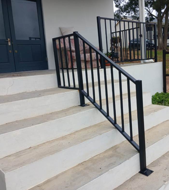 Black steel handrail and balustrade fitted to concrete entrance steps