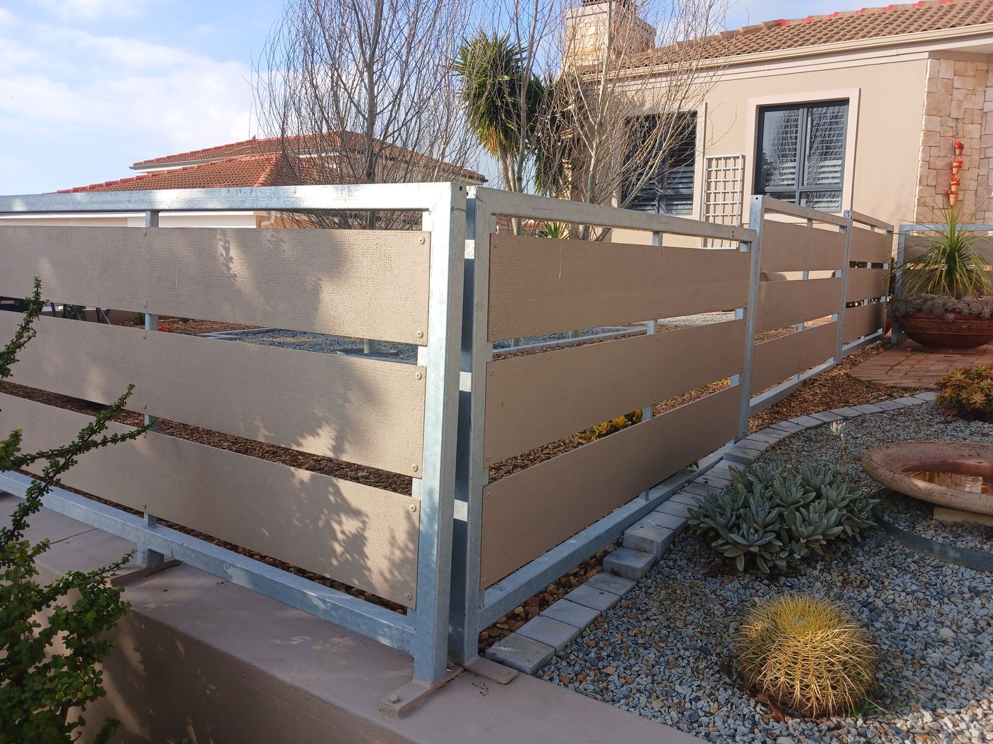 Galvanised steel boundary fence with horizontal slat infill panels