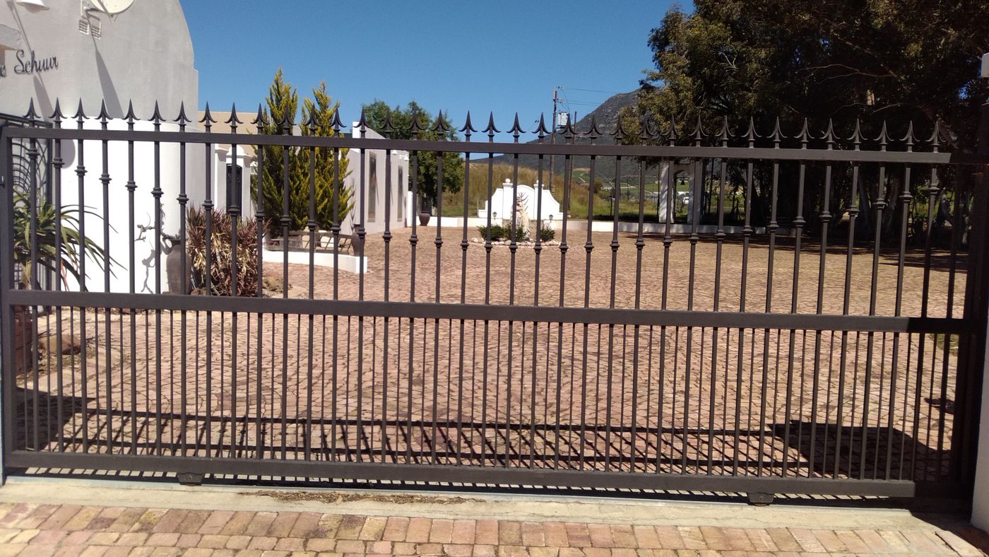 Black ornamental steel driveway gate with decorative scrollwork