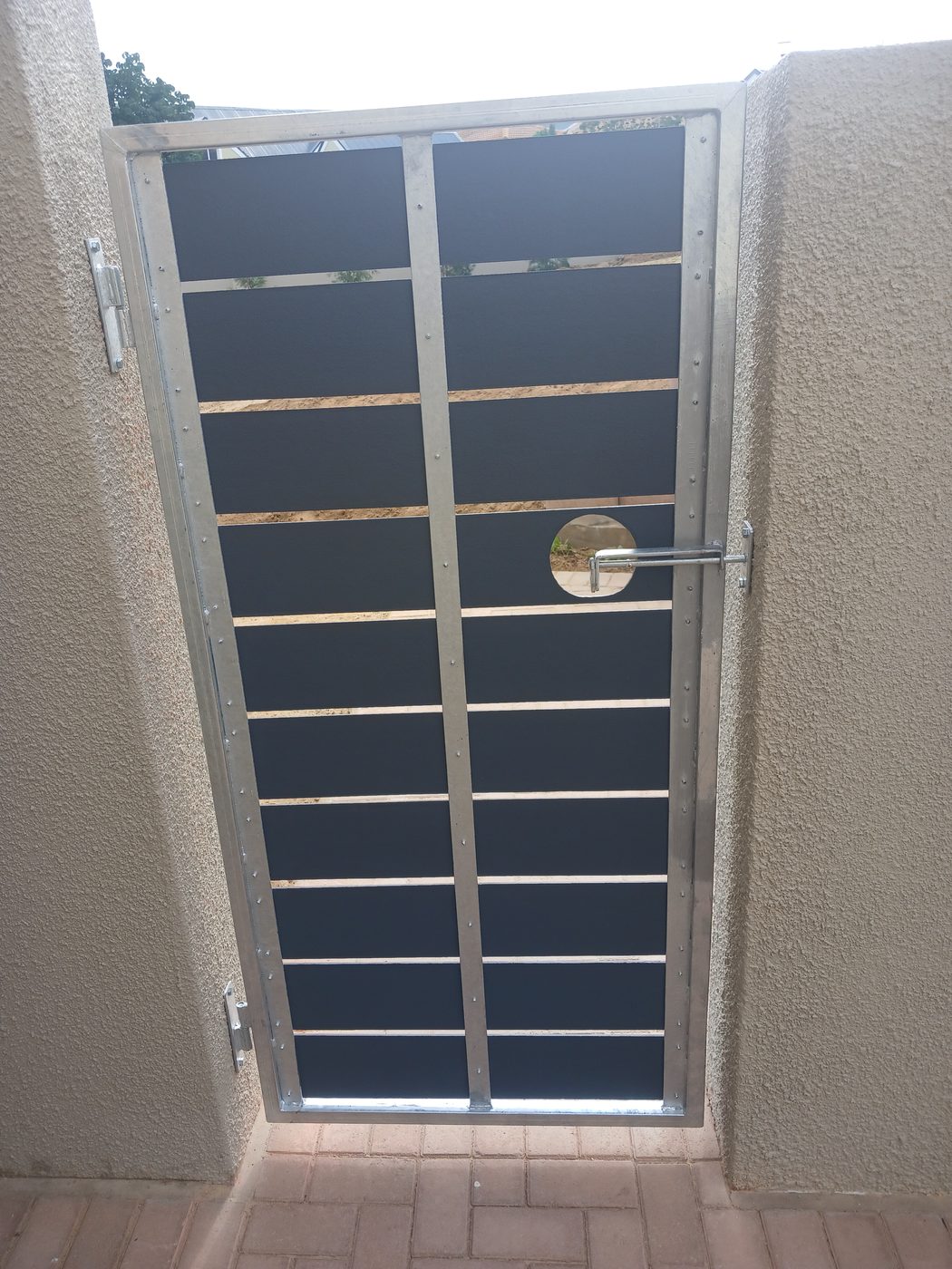 Steel security gate with horizontal bars set into a plastered wall