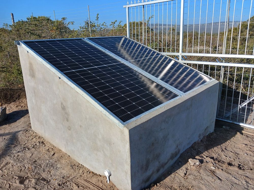 Solar panels on a concrete housing beside a gate