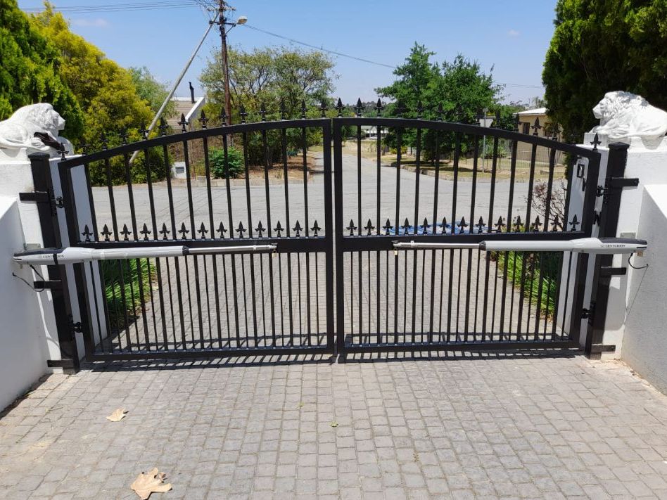 Black steel double swing gate fitted with automatic arm motors