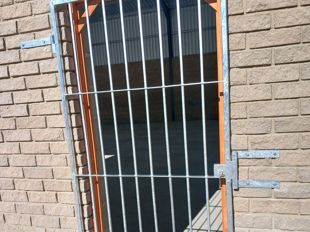Galvanised steel security bar door set into a face-brick wall
