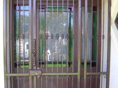 Ornate steel security gate and door set at a front entrance