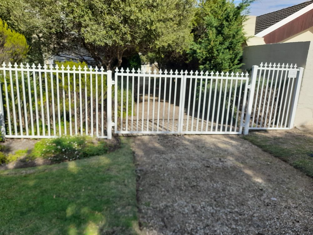 White steel palisade fence and double gate in a garden