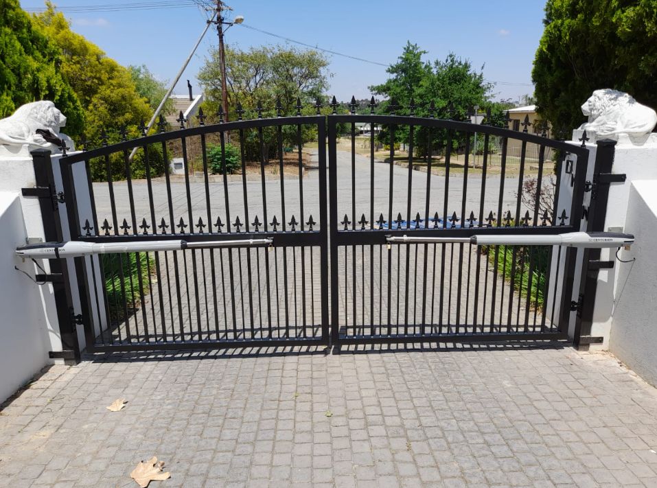 Black steel double swing gate fitted with automatic arm motors